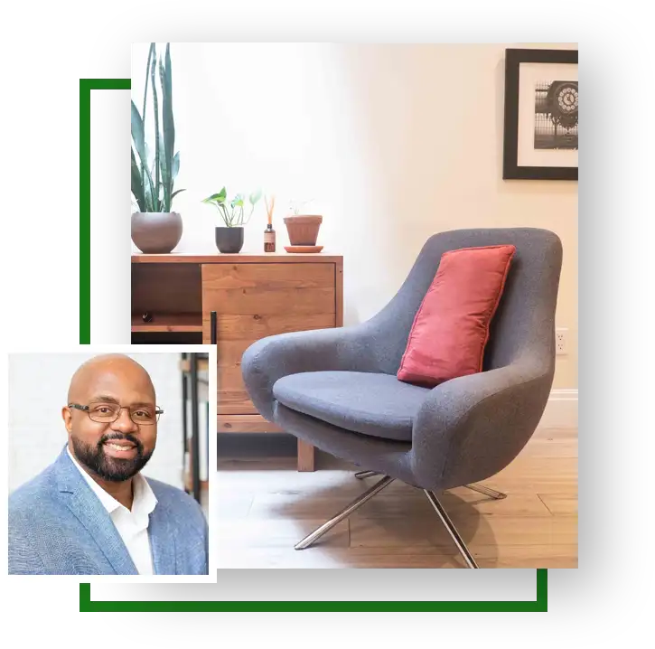 Man in glasses sitting next to a chair.